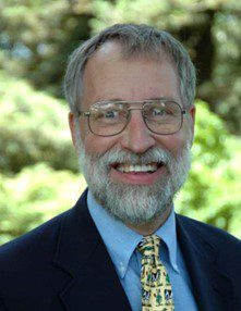 A man with glasses and beard wearing a suit